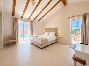 a bedroom with a bed and two windows at Orebic Luxury Villa Leopold in Orebić
