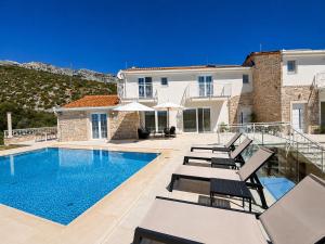 a villa with a swimming pool and lounge chairs at Orebic Luxury Villa Leopold in Orebić