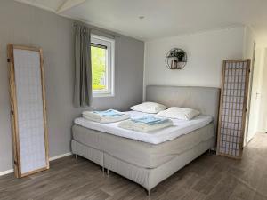 a bedroom with a bed with two pillows and a window at Natuurhuisje Abcoude - De Smient - Best Family Stay in Abcoude +14 photos