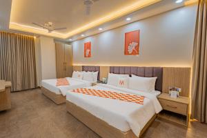 a hotel room with two beds in a room at Mosaic Connect Ayodhya in Ayodhya