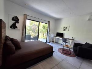 a bedroom with a bed and a desk with a computer at Casa Pavezin in Mahahual