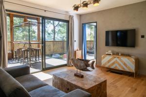 a living room with a couch and a tv and a table at Villa Occitana in Calvisson