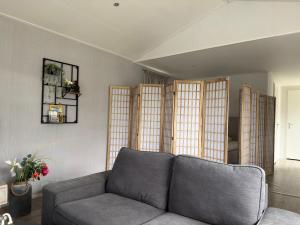 a living room with a couch and some windows at Natuurhuisje Abcoude - De Smient - Best Family Stay in Abcoude