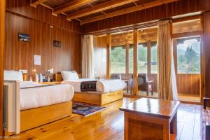 a bedroom with two beds and a table and a window at Valley Resort in Jakar +2 photos