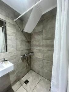 a bathroom with a sink and a shower at The Beach House - Apartments & Studios in Afitos