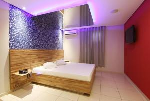 a bedroom with a bed with a purple lighting at Flow Motel (Adult Only) in Valinhos