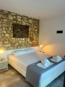a bedroom with a bed with towels on it at The Beach House - Apartments & Studios in Afitos