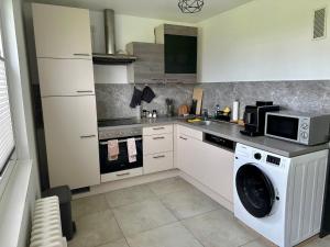 a kitchen with a washing machine and a microwave at Little Royal in Garbsen