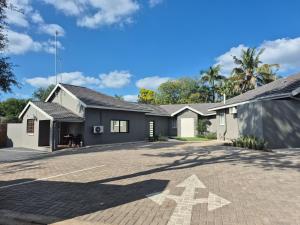 a house with a driveway in front of it at Casa Kruger Lodge in Phalaborwa