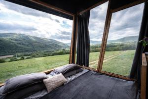 a bed in a room with a large window at Kajuta in Betliar