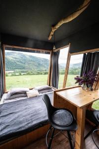 a bedroom with a bed and a desk and a window at Kajuta in Betliar