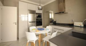 a kitchen with a white table and white chairs at Viila Fernandes with Pool in Pera in Pêra