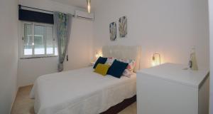 a white bedroom with a bed and a window at Viila Fernandes with Pool in Pera in Pêra