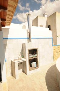 a outdoor kitchen with a fireplace on a building at Viila Fernandes with Pool in Pera in Pêra