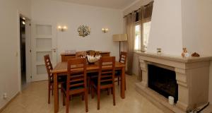 a dining room with a table and a fireplace at Viila Fernandes with Pool in Pera in Pêra