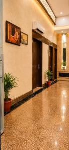 a lobby with a painting on the wall and plants at Hotel Embassy Star Taaj Agra - Budget Ac Rooms Near Taj in Agra +8 photos
