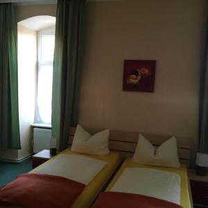 2 camas en una habitación con ventana en Pension Gutshaus, en Halle an der Saale