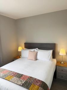 a bedroom with a large white bed with a pink pillow at Balreask Bar, Restaurant & Guest Accommodation in Navan