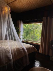 a bedroom with a bed with a window at อะบู้ศรีโฮมสเตย์ in Ban Huai Khai