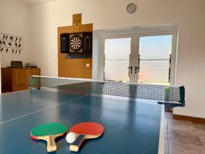 a ping pong table with two ping pong paddles on it at The Stables in Llandysul