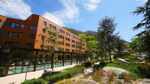 a building with a swimming pool in front of it at Vila Galé Collection Serra da Estrela in Manteigas
