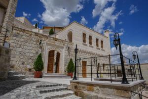 a large stone building with a gate in front of it at Sinasos Evleri in Nevşehir