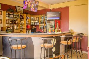 un bar con cuatro taburetes en un mostrador en Eland Safari Hotel Nyeri en Nyeri