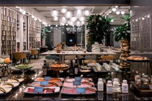 a restaurant with tables filled with food on display at NH Collection Olomouc Congress in Olomouc