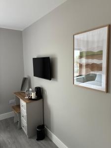 a room with a desk and a television on a wall at Balreask Bar, Restaurant & Guest Accommodation in Navan +10 photos