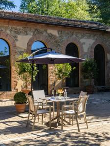 a table and chairs with an umbrella on a patio at Guild Siena Senior Resort & Residence in Siena