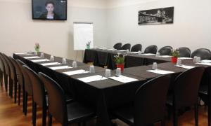 a conference room with long tables and chairs and a presenter at Hotel Star in Monterotondo