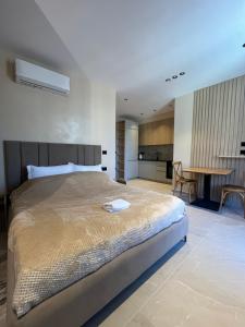 a bedroom with a large bed and a kitchen at Ciel Apartement in Orikum +20 photos