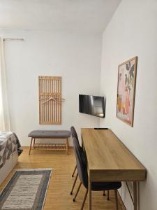 a room with a table and a chair and a television at Apartmani Banić Apartman Studio 3 in Postira