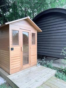 a small wooden shed with a wooden deck at Orchard House Holiday in Bungay