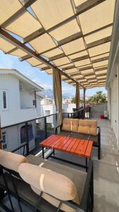 eine Terrasse mit Bank und Stühlen auf einem Balkon in der Unterkunft Boutique Natural Apart Hotel in Kemer