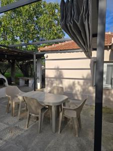 a table and chairs and an umbrella on a patio at Olive garden cottage, Krines in Vélon