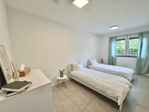 a bedroom with two beds and a table and a window at KiNi Unterkunft in Hörstel