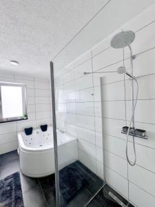 a white bathroom with a shower and a bath tub at KiNi Unterkunft in Hörstel