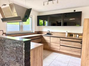 a kitchen with wooden cabinets and a stone wall at KiNi Unterkunft in Hörstel