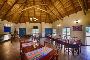 een eetkamer met tafels en stoelen in een gebouw bij Awelani Lodge in Masisi