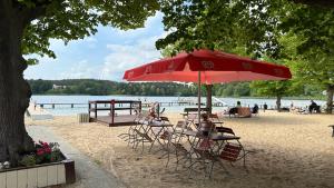 a beach with a table and chairs and an umbrella at Dom przy Panke in Kolonie Röntgental
