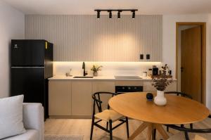 a kitchen with a table and a black refrigerator at Garden Atelier - Private Cenote & Steps from the Beach in Tulum +19 photos