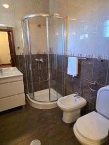 a bathroom with a shower and a toilet and a sink at Lúcia's House in Santa Cruz +16 photos
