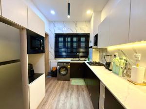 a kitchen with a washer and a washing machine in it at Luxury 1 BR With Swimming Pool & 24 Hours Security In Lekki 1 in Lagos
