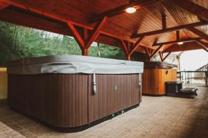 a hot tub in a building with a roof at Eged Panzió Eger in Eger