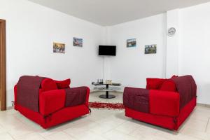 a living room with two red chairs and a tv at La Perla in Latiano