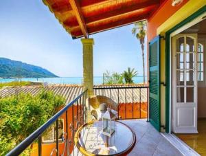 a balcony with a glass table and a view of the ocean at Caramela Beach House in Agios Georgios Pagon