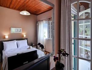a bedroom with a bed and a window at Caramela Beach House in Agios Georgios Pagon
