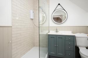 a bathroom with a toilet and a sink and a mirror at Town Farm Cottages Beadnell by Coast & Country Stays in Beadnell +70 photos