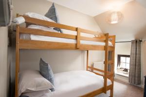a bedroom with two bunk beds in a room at Town Farm Cottages Beadnell by Coast & Country Stays in Beadnell